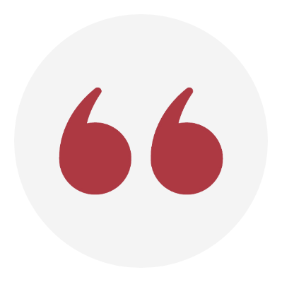 A red quotation mark symbol inside a white circle on a gray background.