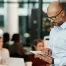 a business man inspects an ipad during a corporate team meeting to grow his business and updated the technology software