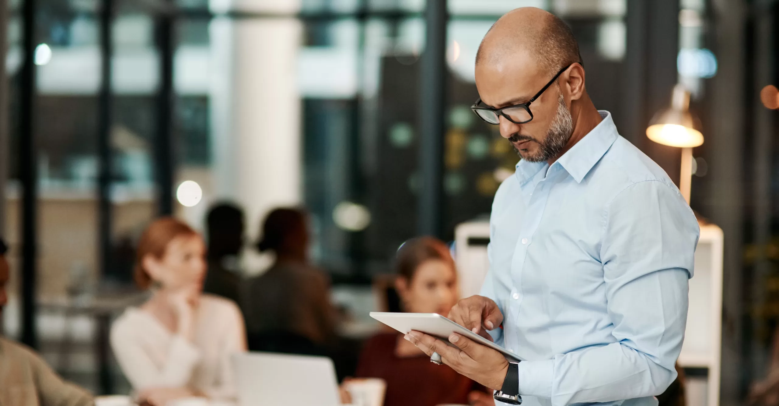 a business man inspects an ipad during a corporate team meeting to grow his business and updated the technology software